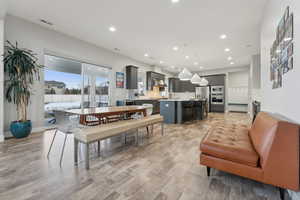 Dining room with light hardwood / wood-style floors and beverage cooler