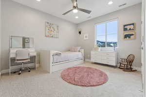 Carpeted bedroom featuring ceiling fan