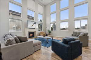 Living room featuring a towering ceiling and light hardwood / wood-style floors