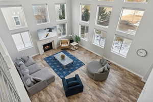 Living room with a towering ceiling and hardwood / wood-style flooring