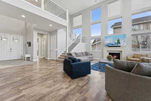 Living room with wood-type flooring and a towering ceiling