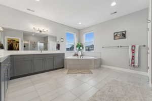 Bathroom featuring plus walk in shower, vanity, and tile patterned floors