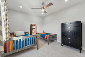 Carpeted bedroom featuring ceiling fan