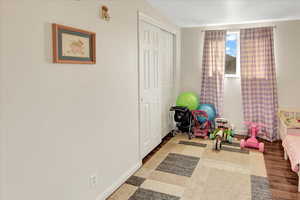 Playroom featuring hardwood / wood-style flooring and vaulted ceiling