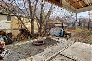 View of patio featuring a trampoline and an outdoor fire pit