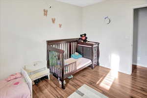 Bedroom featuring a crib and hardwood / wood-style floors