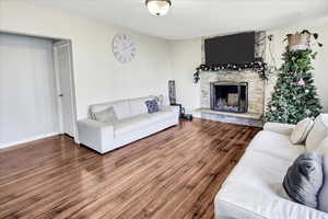 Living room featuring hardwood / wood-style floors and a stone fireplace