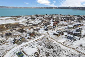 Snowy aerial view featuring a water and mountain view