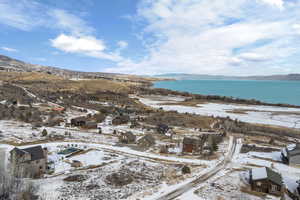 Snowy aerial view with a water and mountain view