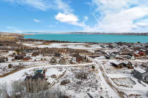 Snowy aerial view featuring a water and mountain view