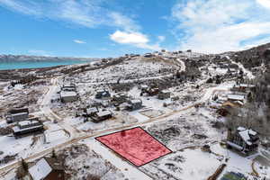 Snowy aerial view featuring a water and mountain view