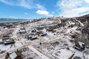 Snowy aerial view featuring a water and mountain view