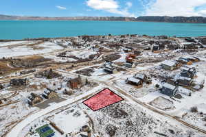 Snowy aerial view featuring a water and mountain view