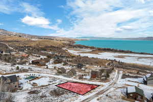 Snowy aerial view featuring a water and mountain view