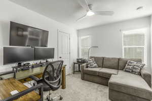 Home office featuring light carpet and ceiling fan