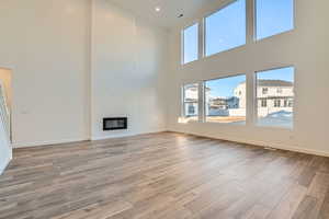 Unfurnished living room featuring a towering ceiling and LVP flooring