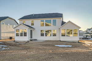 Back house at dusk featuring a patio