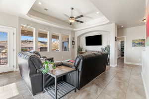 Living room featuring a tray ceiling and ceiling fan