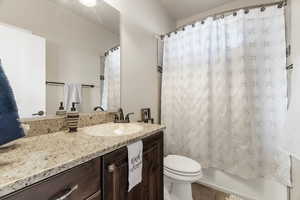 Full bathroom with tile patterned flooring, vanity, toilet, and shower / tub combo