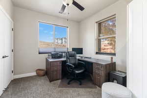 Carpeted office featuring plenty of natural light and ceiling fan