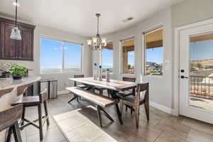 Tiled dining area featuring a notable chandelier