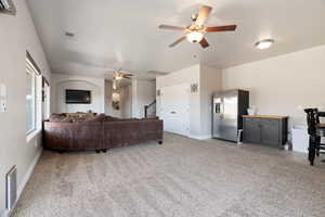 Living room with ceiling fan and light carpet