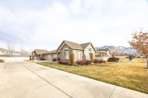 Ranch-style house featuring a mountain view, a garage, and a front yard