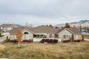 Single story home featuring a mountain view and a front lawn