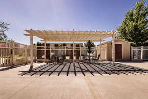 View of patio featuring a shed and a pergola