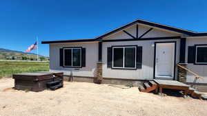 View of front of property with a mountain view and a hot tub