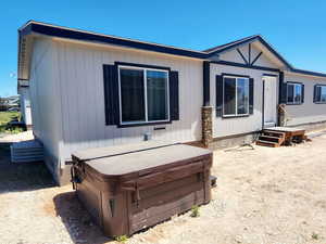 Rear view of property with a hot tub