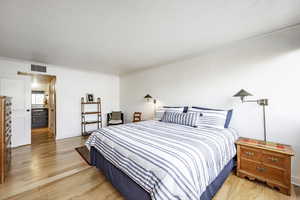 Bedroom with light hardwood / wood-style flooring and ornamental molding