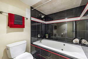 Bathroom with toilet and tiled shower / bath