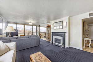 Living room with hardwood / wood-style floors, ornamental molding, and a textured ceiling