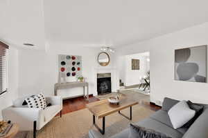 Living room featuring wood-type flooring and a high end fireplace