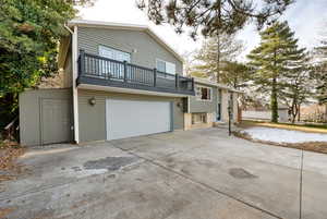 Back of house with a garage and a balcony