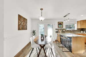 Dining space with sink, french doors, and light wood-type flooring