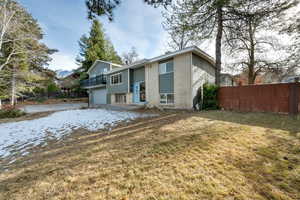 Back of house with a yard and a garage