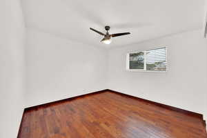 Empty room featuring hardwood / wood-style floors and ceiling fan