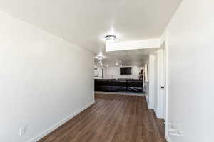 Corridor featuring a textured ceiling and dark hardwood / wood-style floors