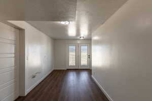 Interior space featuring dark wood-type flooring and a textured ceiling