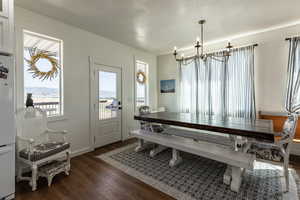 Dining space with a chandelier and dark hardwood / wood-style floors