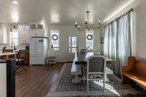 Dining area featuring dark hardwood / wood-style floors, a notable chandelier, and sink