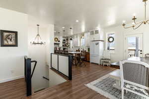 Interior space featuring a notable chandelier and dark wood-type flooring