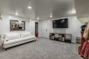 Carpeted living room featuring a textured ceiling