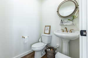 Bathroom with hardwood / wood-style flooring and toilet