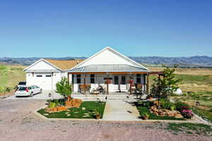 View of front of home featuring a mountain view, a porch, and a garage