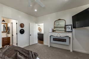 Carpeted bedroom with ceiling fan and ensuite bathroom