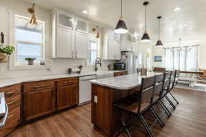 Kitchen with a center island, white appliances, a kitchen breakfast bar, sink, and dark hardwood / wood-style floors