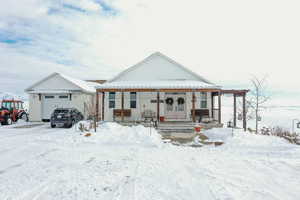 View of front of house featuring a porch, a garage, and french doors